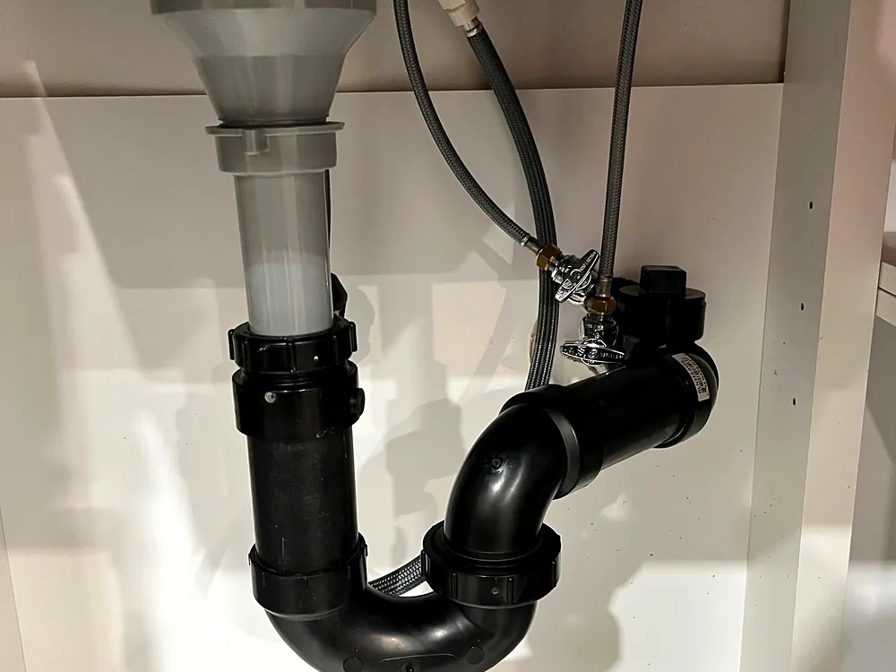 New black P-trap and drain under a bathroom sink