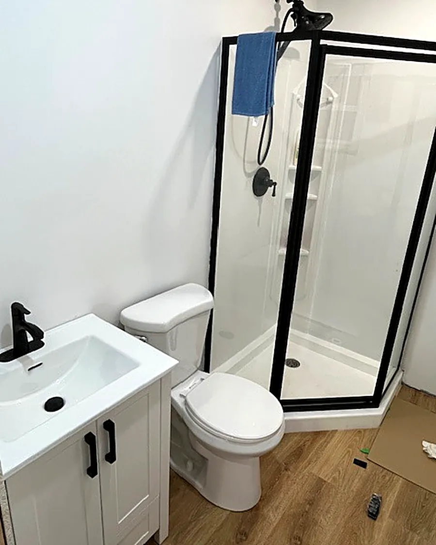 Bathroom with corner shower, toilet and white vanity
