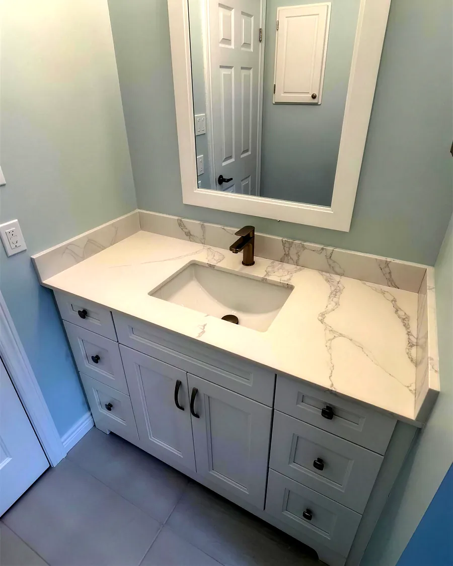 White shaker vanity with quartz top and bronze faucet